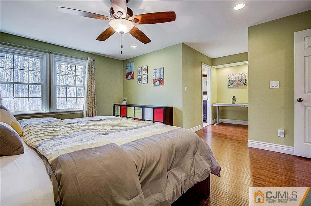 4505 Stonehedge Road Edison, NJ 08820 - Photo 13 of 25 a spacious bedroom with a bed and a table with wooden floor