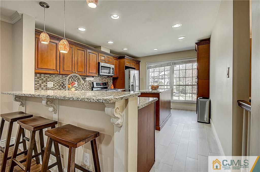 4505 Stonehedge Road Edison, NJ 08820 - Photo 7 of 25 a kitchen with stainless steel appliances granite countertop wooden cabinets a stove top oven a sink and dishwasher