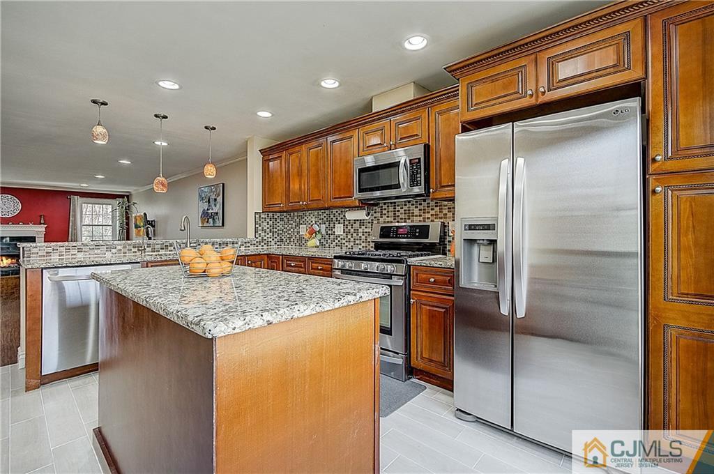 4505 Stonehedge Road Edison, NJ 08820 - Photo 9 of 25 a kitchen with stainless steel appliances granite countertop a refrigerator a stove and a sink