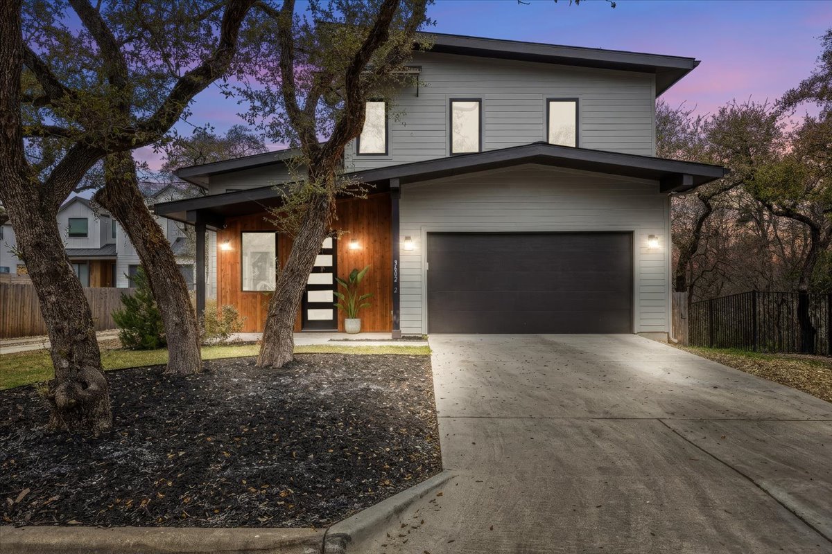 A sleek exterior design and attached two-car garage offer both style and everyday convenience.