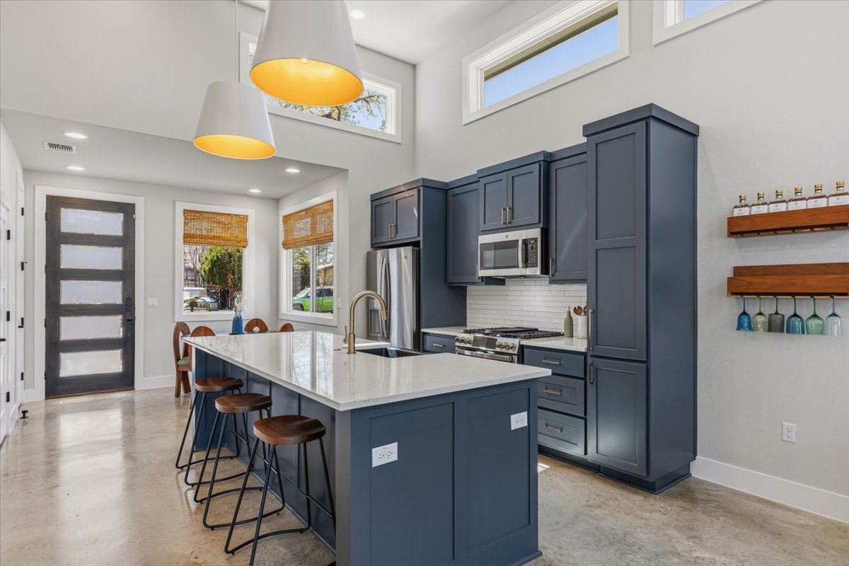 a kitchen with stainless steel appliances granite countertop a refrigerator and a stove top oven