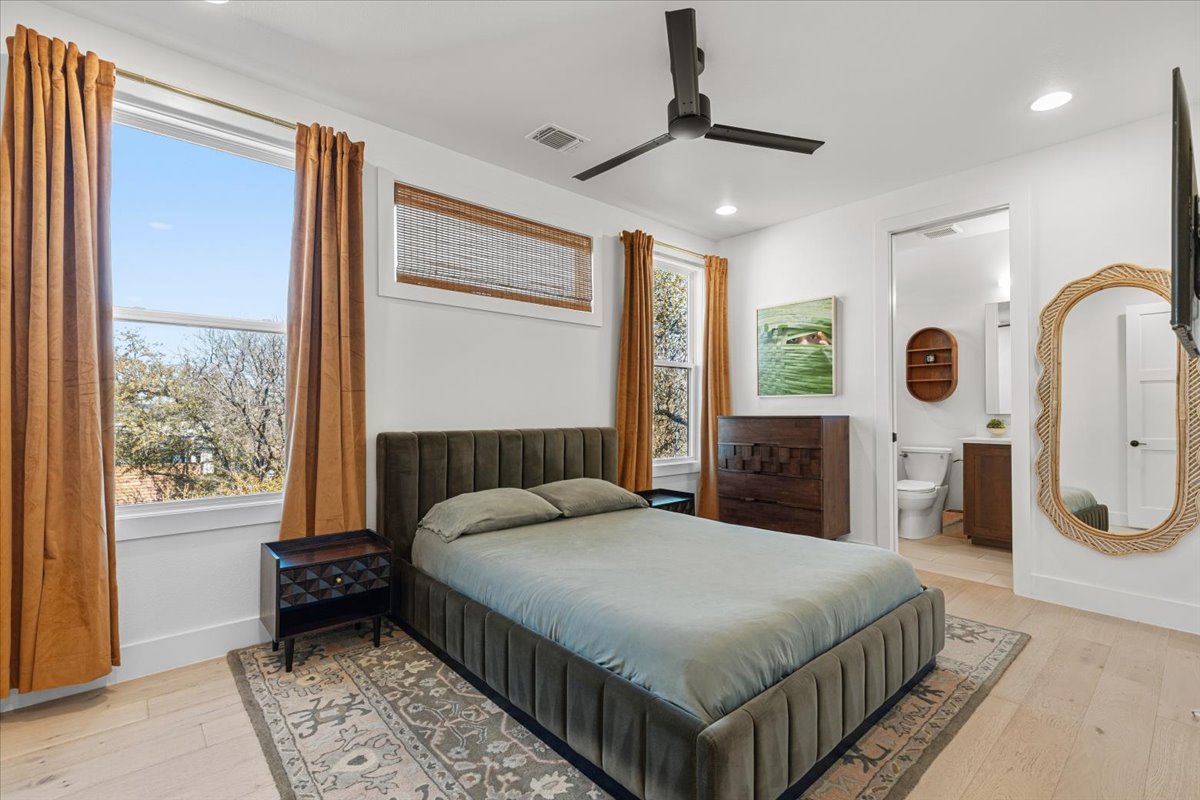 3602 Pennsylvania Avenue, Unit 2 Austin, TX 78721 - Photo 12 of 32 The upstairs primary suite offers a peaceful retreat with warm wood flooring.