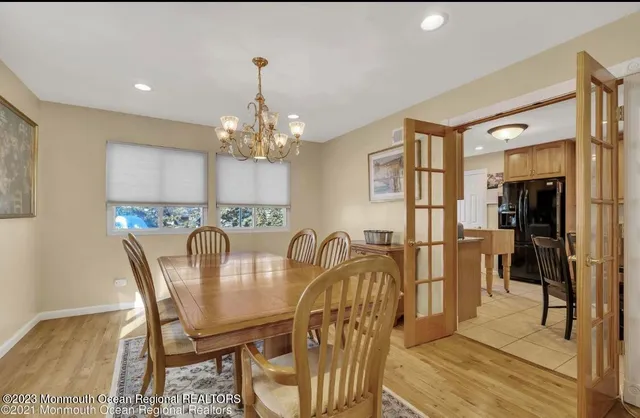 a dining room with furniture a chandelier and wooden floor