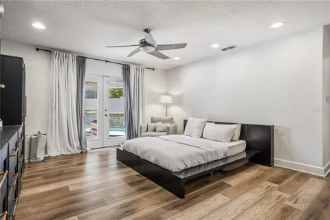 a bedroom with a large bed and a flat tv screen on dresser