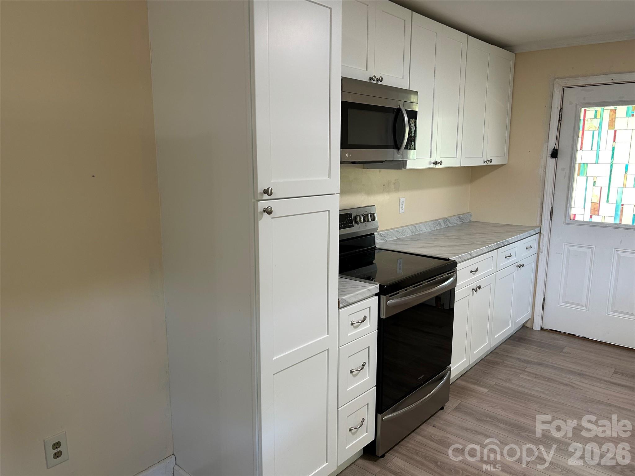 2307 Harris Henrietta Road Forest City, NC 28043 - Photo 11 of 31 a kitchen with stainless steel appliances white cabinets and a stove top oven