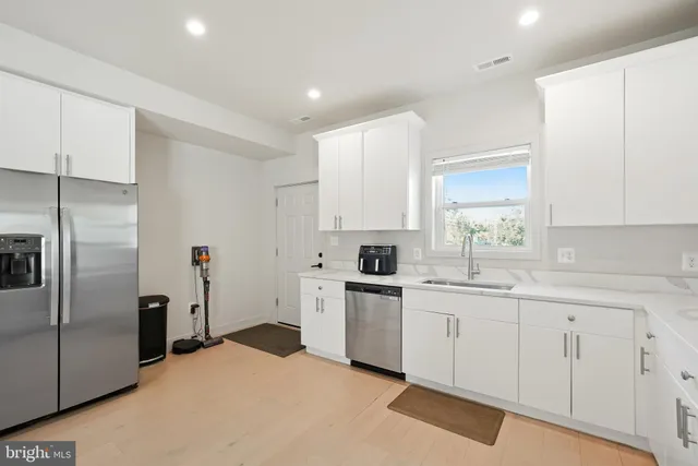 a kitchen with white cabinets and stainless steel appliances