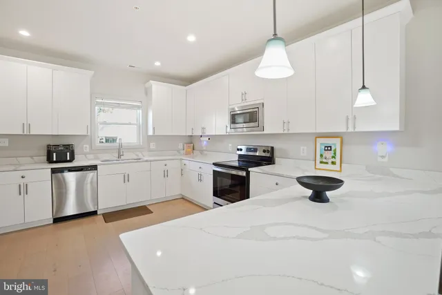 a kitchen with stainless steel appliances a stove sink and cabinets