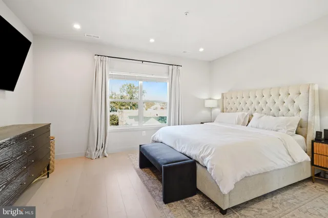 a spacious bedroom with a large bed and a flat screen tv