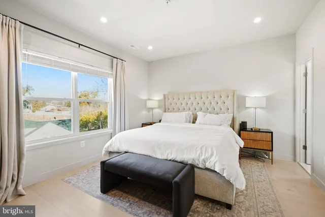 a bedroom with a bed and a large window