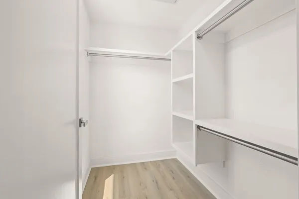 a view of walk in closet with empty racks