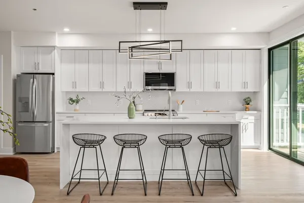 a kitchen with stainless steel appliances granite countertop a white cabinets and a refrigerator