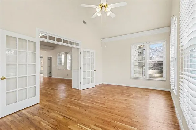 a view of an empty room with wooden floor and a window