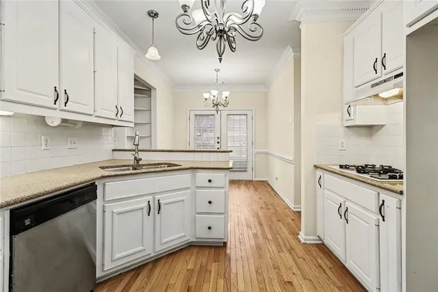 a kitchen with stainless steel appliances granite countertop a sink a stove and cabinets