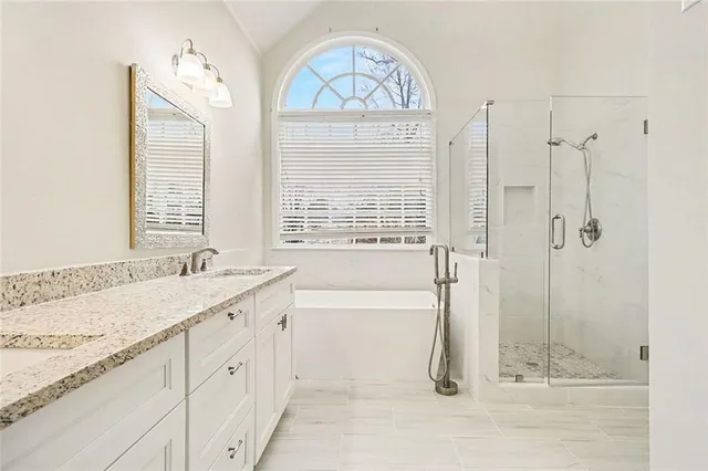 a bathroom with a granite countertop sink a toilet a vanity and shower