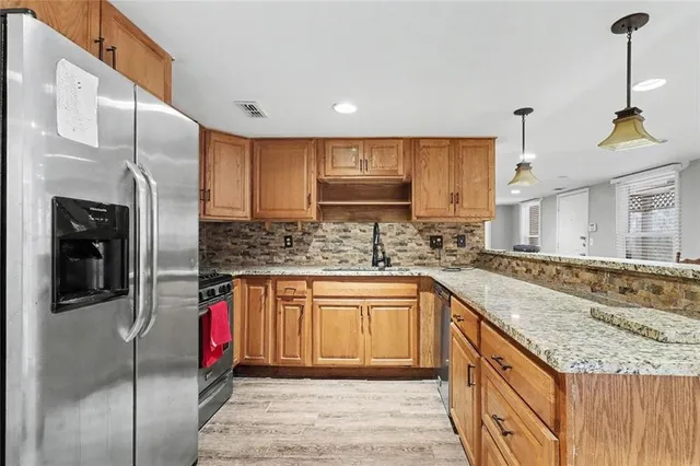 a kitchen with stainless steel appliances granite countertop a sink stove and refrigerator
