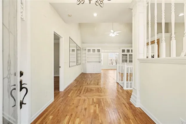 a view of a hallway with wooden floor and staircase