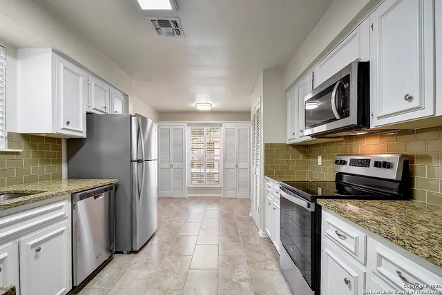 a kitchen with stainless steel appliances granite countertop a refrigerator stove and microwave