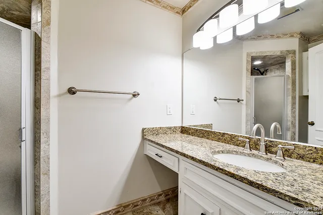 a bathroom with a granite countertop sink and a mirror