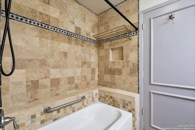 a bathroom with a white bath tub a shower and a sink