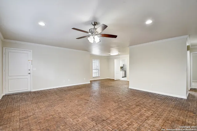 a view of a big room with a ceiling fan and a window