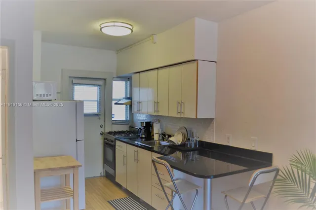 a kitchen with a sink refrigerator and cabinets