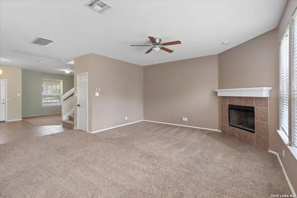 an empty room with fan and windows