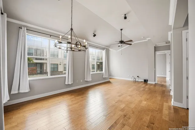 a view of a room with wooden floor fireplace and windows