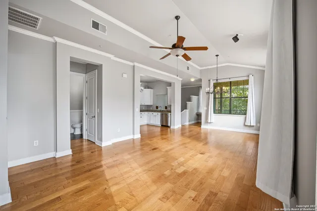 a view of an empty room with window and wooden floor