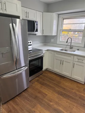 a kitchen with stainless steel appliances a refrigerator sink and microwave