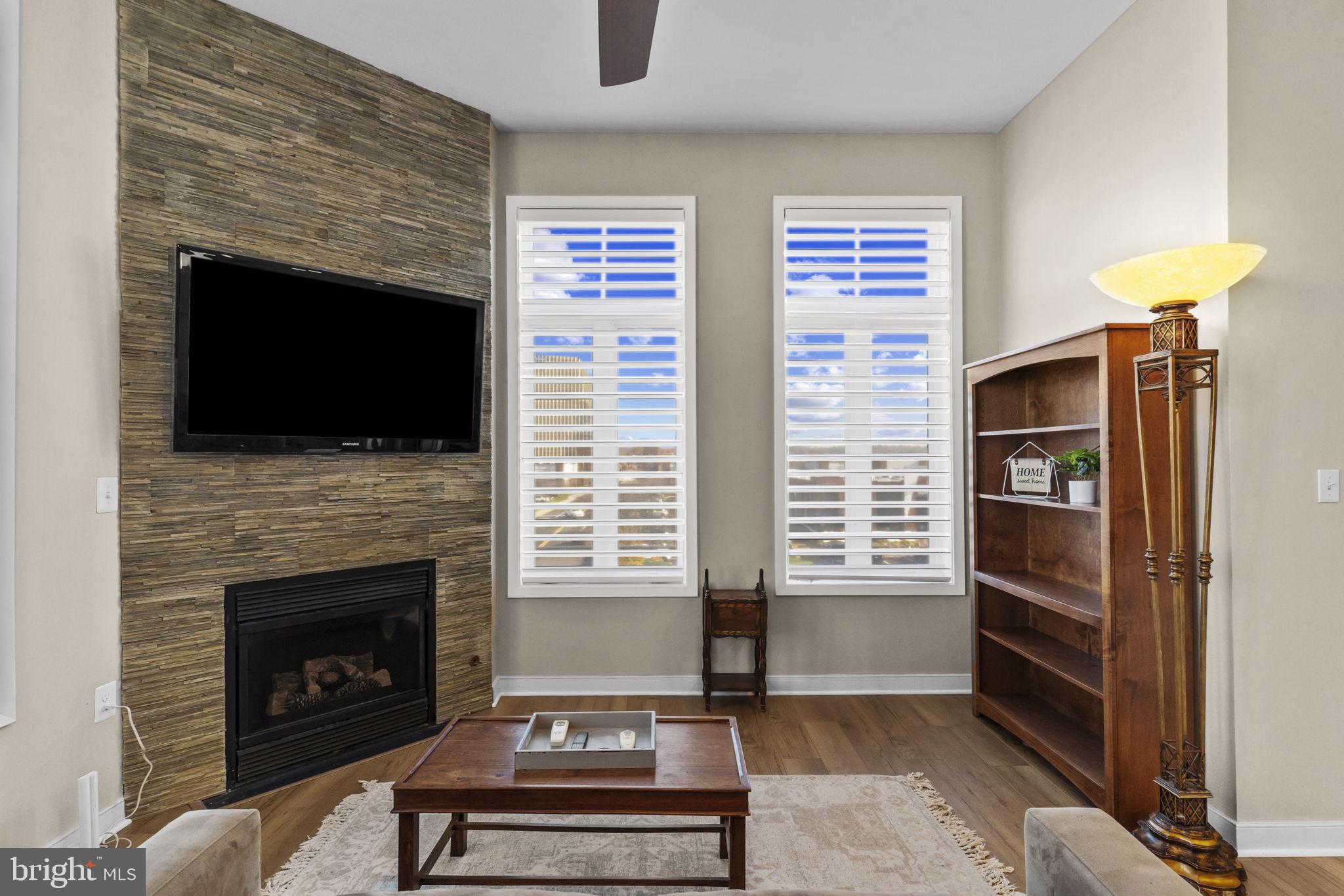 181 East Reed Avenue, Unit 411 Alexandria, VA 22305 - Photo 2 of 24 a living room with furniture a flat screen tv and a fireplace