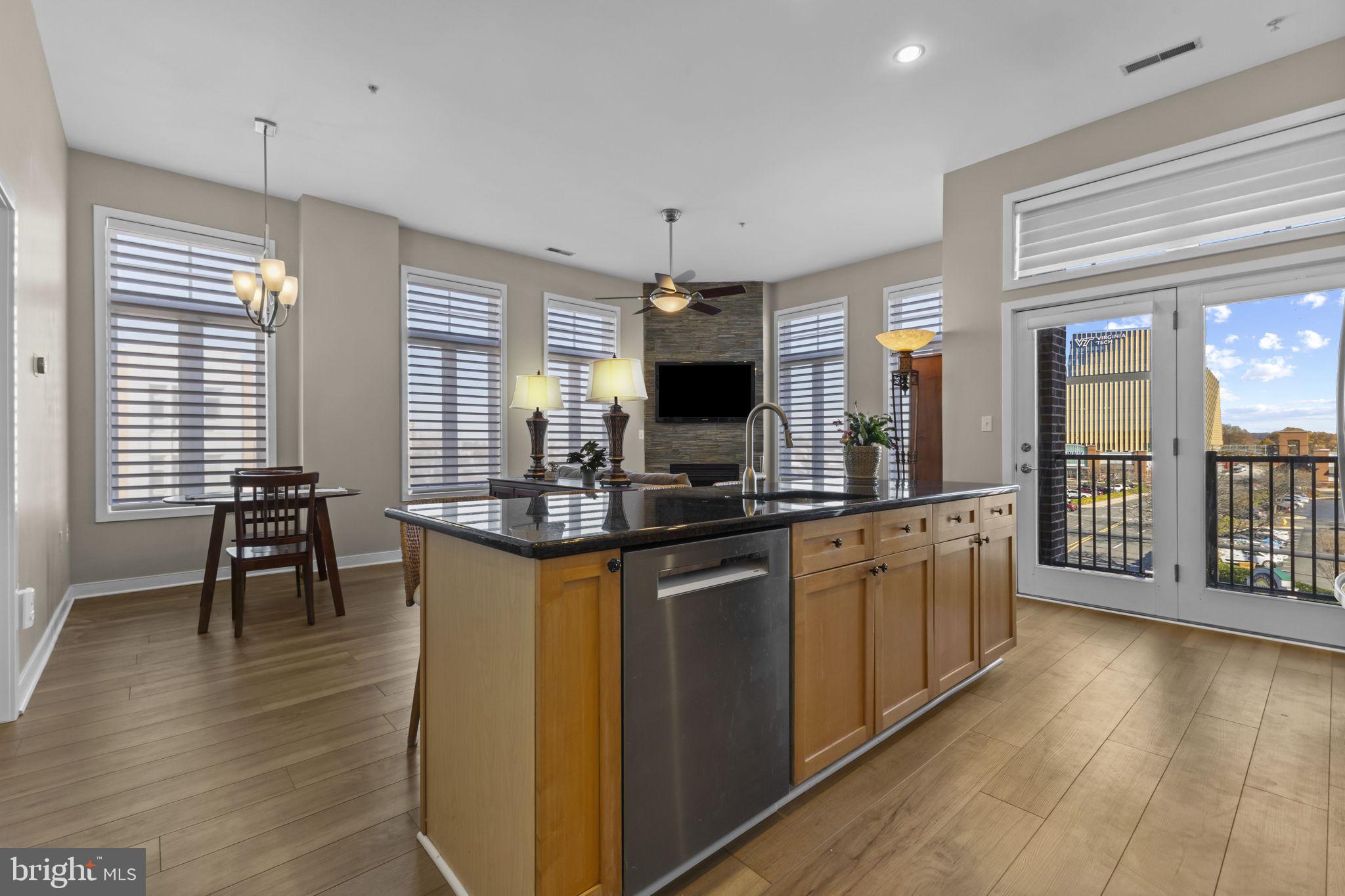 181 East Reed Avenue, Unit 411 Alexandria, VA 22305 - Photo 7 of 24 a kitchen with stainless steel appliances granite countertop a stove top oven a sink dishwasher a dining table and chairs with wooden floor