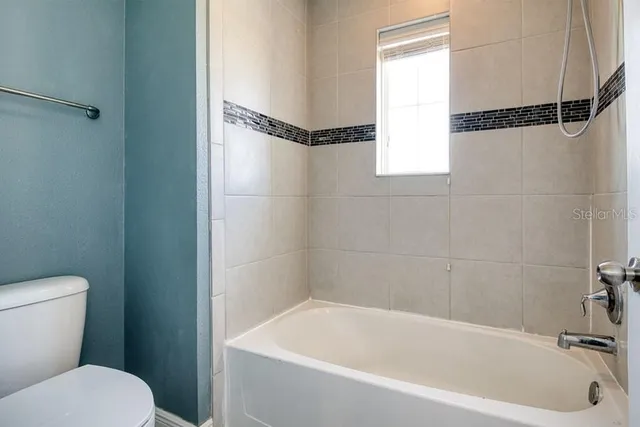 a white bath tub sitting next to a toilet