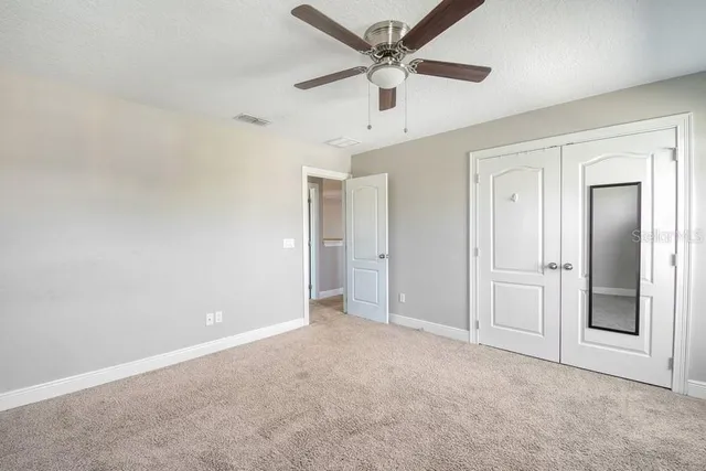 an empty room with chandelier fan