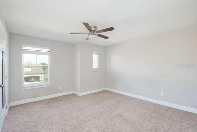 an empty room with a window and a fan