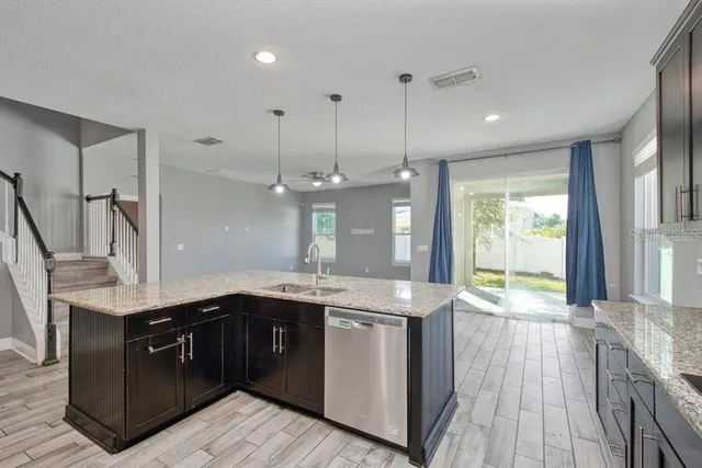 a kitchen with a sink a counter space appliances and cabinets