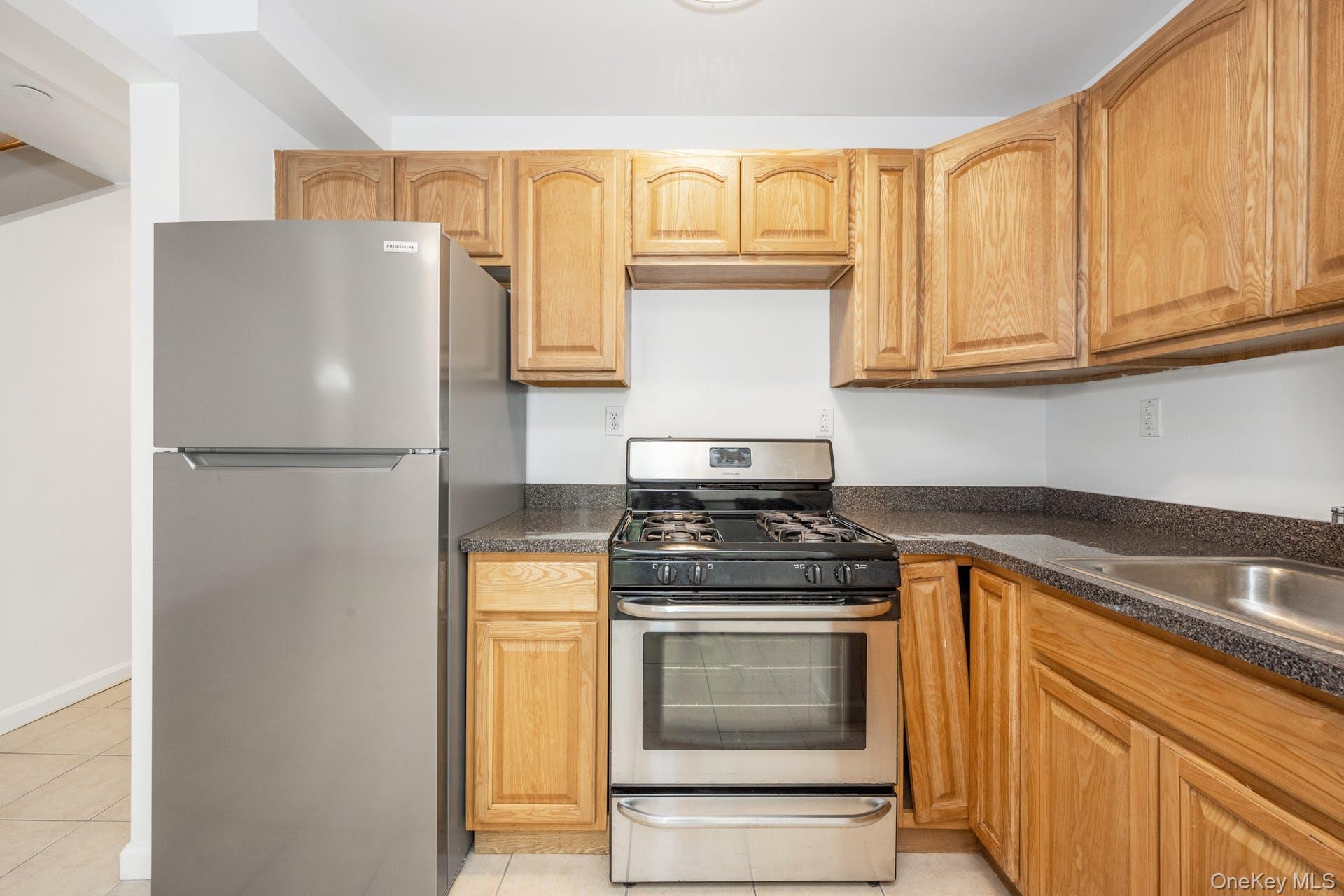 3313 Rombouts Avenue Bronx, NY 10475 - Photo 13 of 44 a kitchen with stainless steel appliances granite countertop a refrigerator stove and cabinets