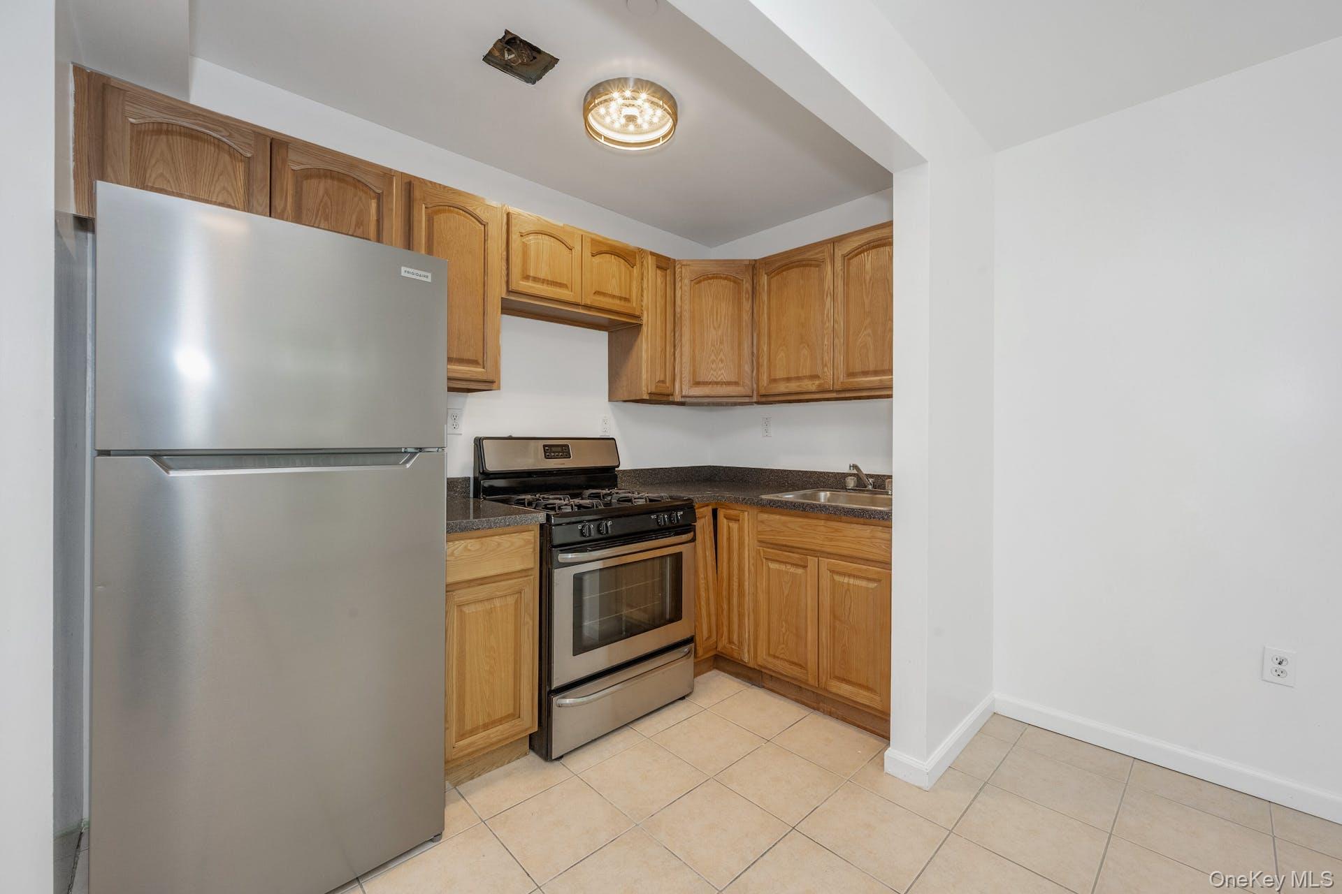 3313 Rombouts Avenue Bronx, NY 10475 - Photo 14 of 44 a kitchen with stainless steel appliances granite countertop a refrigerator a stove a sink and dishwasher