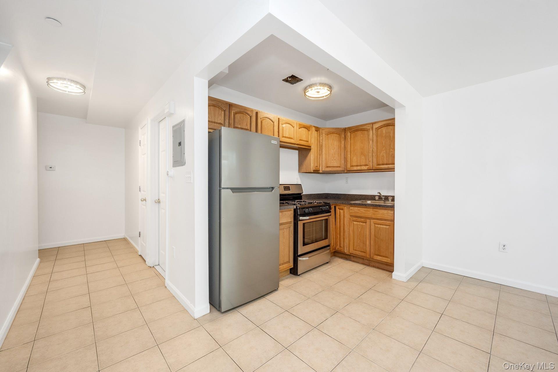 3313 Rombouts Avenue Bronx, NY 10475 - Photo 15 of 44 a kitchen with granite countertop a refrigerator and a stove top oven