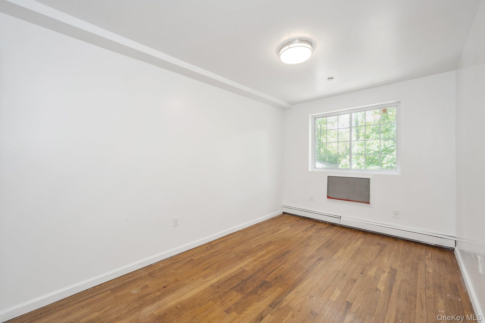 3313 Rombouts Avenue Bronx, NY 10475 - Photo 17 of 44 an empty room with wooden floor and windows