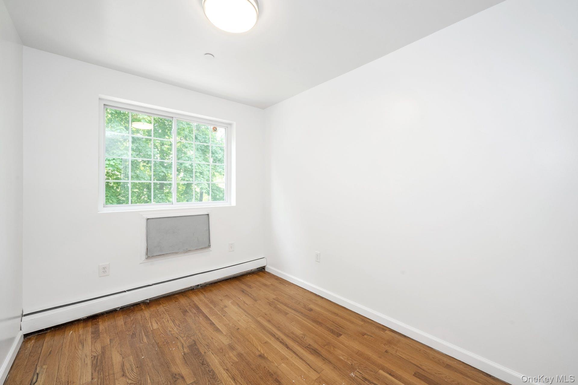 3313 Rombouts Avenue Bronx, NY 10475 - Photo 20 of 44 a view of an empty room with wooden floor and a window