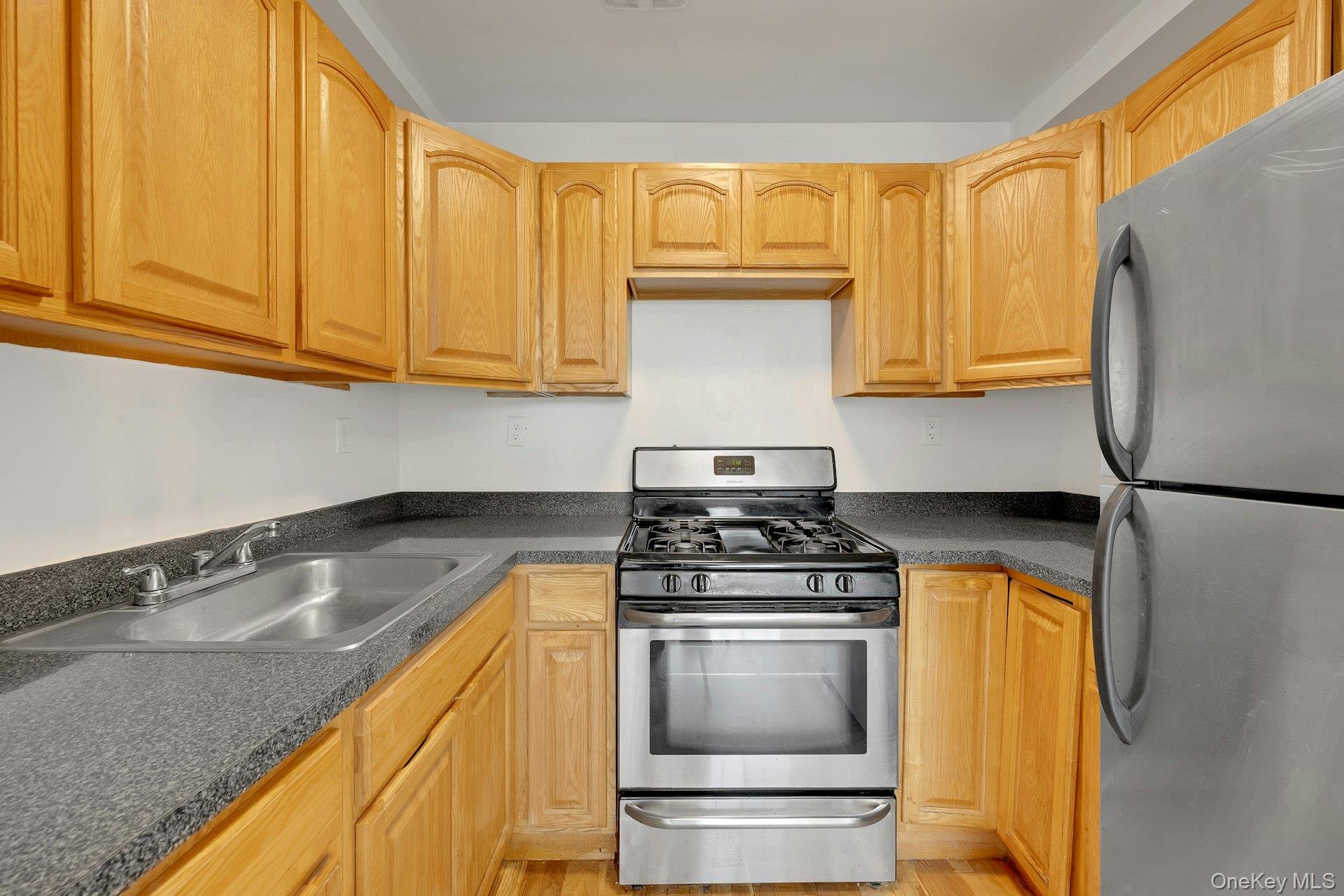 3313 Rombouts Avenue Bronx, NY 10475 - Photo 36 of 44 a kitchen with a stove a sink and a microwave