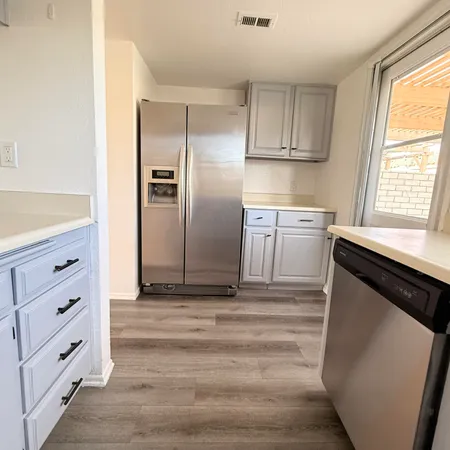 a kitchen with granite countertop cabinets appliances and a window