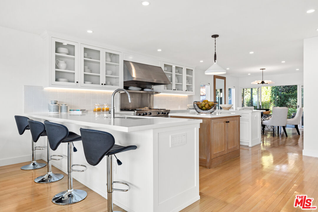 249 Rees Street Playa del Rey, CA 90293 - Photo 12 of 37 a kitchen with stainless steel appliances kitchen island granite countertop a table chairs and a refrigerator
