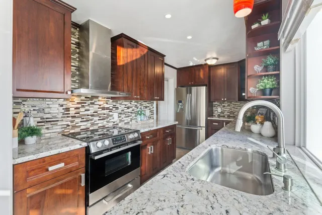 a kitchen with stainless steel appliances granite countertop a sink and a stove