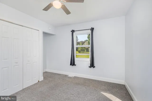 an empty room with windows and closet