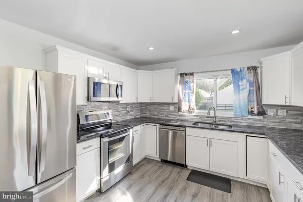 a kitchen with a sink stainless steel appliances and window