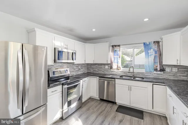 a kitchen with a sink stainless steel appliances and window