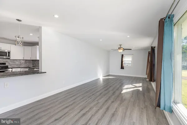 a view of a kitchen with wooden floor and a window