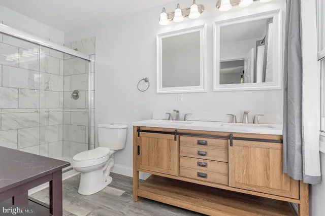 a bathroom with a sink a toilet and shower