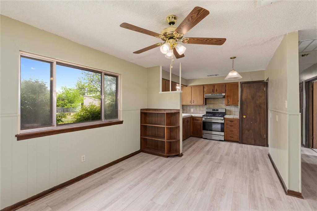 900 West 2nd Street Coleman, TX 76834 - Photo 12 of 28 a view of a kitchen with furniture a ceiling fan and wooden floor